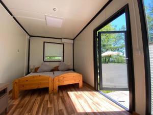 a bedroom with a bed and a large window at Naturerlebnis-Schlafcontainer in Leutershausen