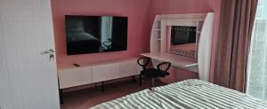 a bedroom with pink walls and a bed and a mirror at ОмниЯ Терас in Chernomorets +9 photos