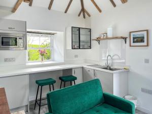 a kitchen with a green chair and a sink at Landberrick Farm Bothy 2 in Newton Stewart