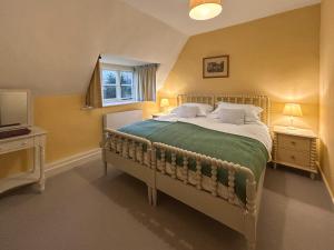 a bedroom with a bed and a window and a television at Grange Cottage in Langham