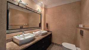 a bathroom with two sinks and a large mirror at Villa Yacout Marrakech -Private Pool in Sraghna +24 photos