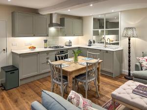 a kitchen and dining room with a table and chairs at Grange Cottage in Langham