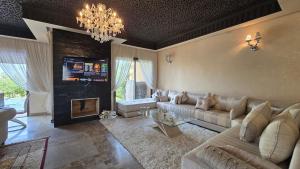 a living room with a couch and a fireplace at Villa Yacout Marrakech -Private Pool in Sraghna