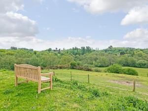 a wooden bench sitting in a field of grass at Forest Edge - Uk51739 in Oakmere