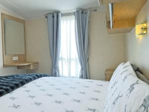 a bedroom with a white bed with a window at Forest Edge - Uk51739 in Oakmere
