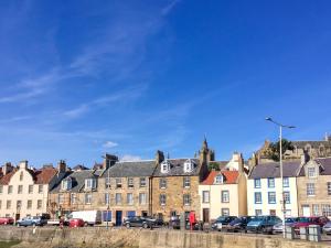 a row of buildings with cars parked in a parking lot at Fisher Gallery in Pittenweem
