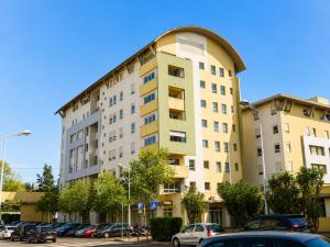 a tall building with cars parked in a parking lot at Lisbon Lux T1 Pool Gym Tennis AC - Pouso dos Anjos Apartment in Lisbon