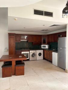 a kitchen with wooden cabinets and a table and appliances at Carlton Luxury Villa in Sharm El Sheikh