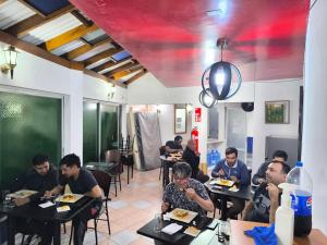a group of people sitting at tables in a restaurant at Zigal hotel in Antofagasta