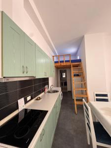 a kitchen with green cabinets and a ladder at Liza's apartment 1f in Skataj