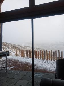 a view of a snow covered field from a window at Casa Malbec en Los Molles in Las Lenas