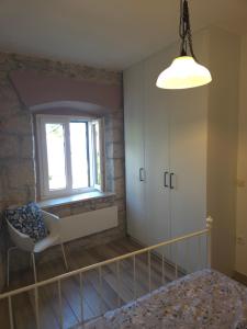 a bedroom with a bed and a window and a chair at Mala Cele in Podgora