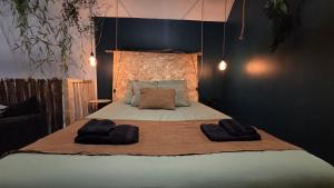 a bedroom with a bed with two towels on it at Botanica - Private Spa in Saint-Quentin