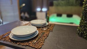 two plates and glasses are sitting on a table at Botanica - Private Spa in Saint-Quentin