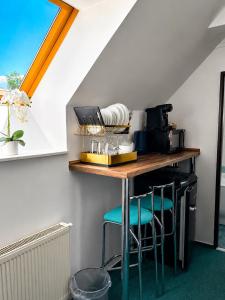 a kitchen with a counter with stools in a room at Hotel Marislav in Češnovice