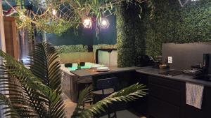 a kitchen with a counter with plants on the wall at Botanica - Private Spa in Saint-Quentin