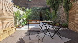 a table and two chairs on a patio at Botanica - Private Spa in Saint-Quentin