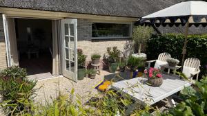 a patio with two chairs and an umbrella at Tulipa Near Beach & Dunes with Free Parking in Noordwijkerhout