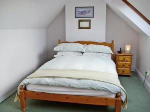 a bedroom with a bed with white sheets and pillows at Haven Cottage - E4342 in Holy Island