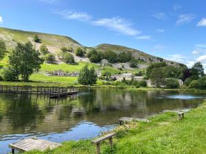 a river with a wooden dock in the middle at Pletts Barn in Grassington