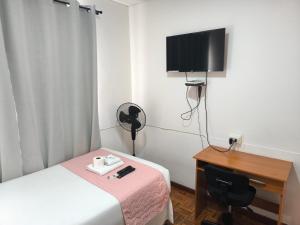 a room with a bed and a desk and a television at Zigal hotel in Antofagasta