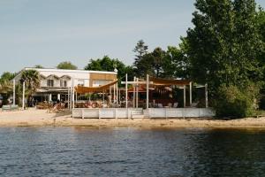 a restaurant on the beach next to the water at Hôtel Latécoère in Biscarrosse
