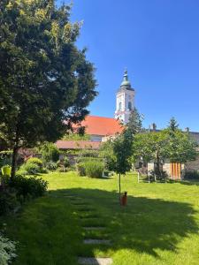 a building with a clock tower in the middle of a yard at Apartmán Silvia in Komárno