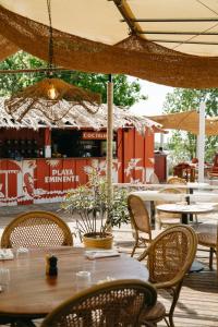 a patio with tables and chairs and a bar at Hôtel Latécoère in Biscarrosse