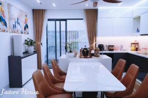 a dining room with a white table and chairs at Jadore House in Danang