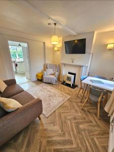 a living room with a couch and a fireplace at Holly Cottage in Edwinstowe