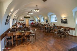 a restaurant with people sitting at tables in a room at Hospoda na sýpce in Kuks