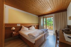 a bedroom with a bed and a table and a window at Hotel St. Pankraz in San Pancrazio dʼUltimo