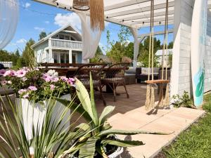a patio with a table and chairs and flowers at Coco Beach Cupel - Domek AQUA z jakuzzi in Cupel