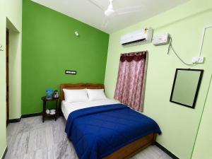 a bed in a room with a green wall at CR Private Villa in Tiruvannāmalai