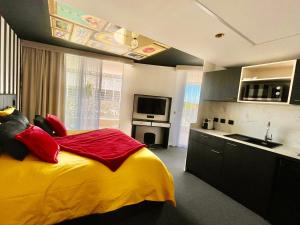 a bedroom with a bed with a yellow and red blanket at Le Royal VIBES in Cap d'Agde