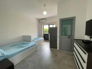 a room with two beds and a refrigerator at Vila Manuel in Shëngjin