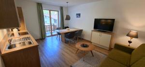 a living room with a couch and a table with a television at valbel in Sankt Anton am Arlberg