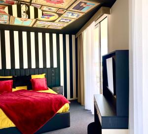 a bedroom with a red bed with a striped ceiling at Le Royal VIBES in Cap d'Agde +31 photos