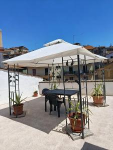 a table and chairs under a white umbrella at La terrazza al 29 in Carbognano
