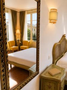 a mirror in a room with a bed and a chair at ISOLA - Smart Accomodation in Messina