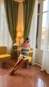 a woman sitting in a chair in a room at ISOLA - Smart Accomodation in Messina