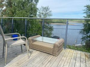 Ein Tisch und Stühle auf einer Terrasse mit Blick auf das Wasser in der Unterkunft Mälarvilla in Strängnäs