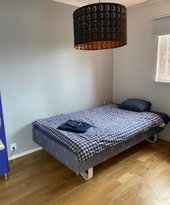 ein Schlafzimmer mit einem Bett in einem Zimmer mit einer Lampe in der Unterkunft Mälarvilla in Strängnäs