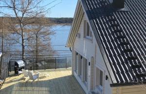 ein Haus mit Balkon und Blick aufs Wasser in der Unterkunft Mälarvilla in Strängnäs
