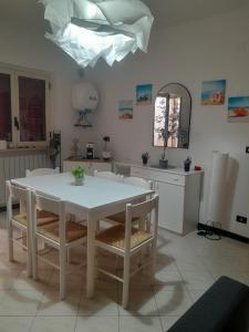 a dining room with a white table and chairs at Vacanze da Paola in Campomarino