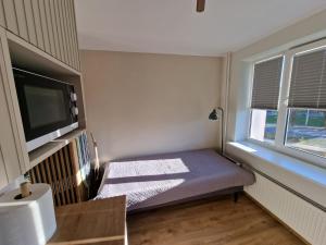 a small room with a bed and a tv at Mini apartment for one person in Tallinn