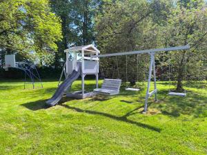 a playground in a park with a swing at Akmenių Dvaras in Akmeniai +59 photos