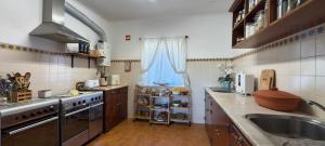 a kitchen with a sink and a stove top oven at CCCA Monte Loureiro in Raposeira