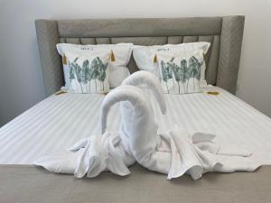 two white swans towels sitting on a bed at Apartament Madagascar Hotel BS by Ella Mamaia Nord in Mamaia Sat/Năvodari