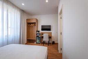a bedroom with a bed and a desk with a television at 266 La Barraca in Torvaianica